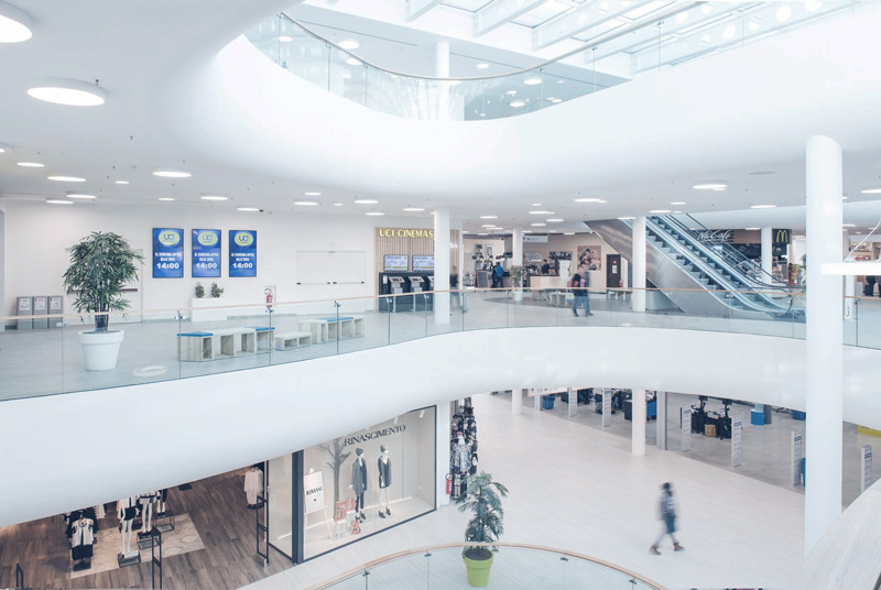 Vista interna dell'estensione del centro commerciale. La ricerca di forme curve degli architetti ha dato come risultato parapetti vetrati curvi che permettono alla luce di entrare negli spazi centrali dell''edificio direttamente dalla grande copertura in acciaio e vetro alla sua sommità.
